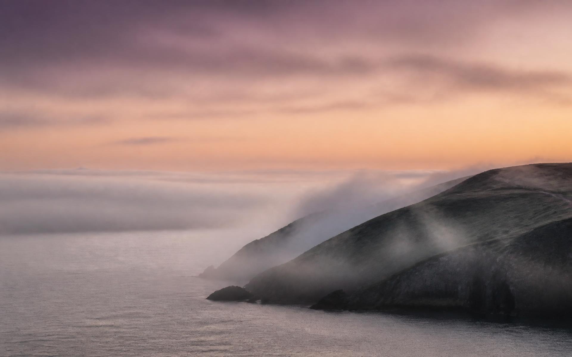 Sea mist drifting across an Irish coastal headland at first light